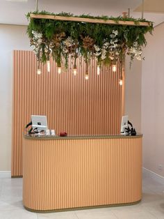 the reception desk is decorated with flowers and greenery hanging from it's ceiling