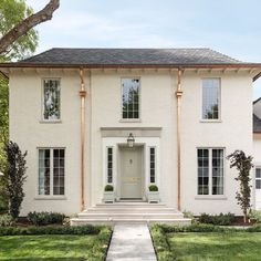 a white house with an entry way leading to the front door