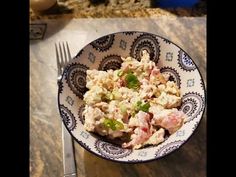 a bowl filled with food sitting on top of a table next to a knife and fork