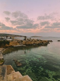 the water is crystal green and clear with people swimming in it at sunset or dawn