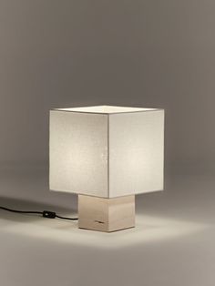 a lamp that is sitting on top of a wooden block with a cord attached to it