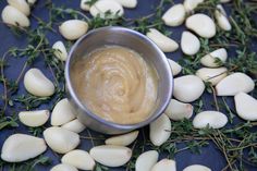 a small metal bowl filled with food on top of a blue table covered in green leaves