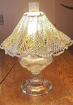 a glass lamp sitting on top of a wooden table