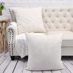 a white couch sitting on top of a hard wood floor next to a wooden table