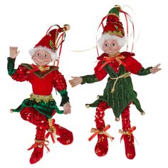 two christmas ornaments hanging from the ceiling, one wearing red and green clothing with gold trimmings