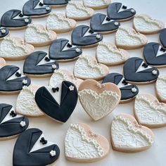 decorated cookies in the shape of hearts and tuxedos are arranged on a table