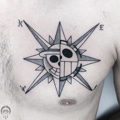 a man's chest with a black and white tattoo design on it, which has a sun in the middle