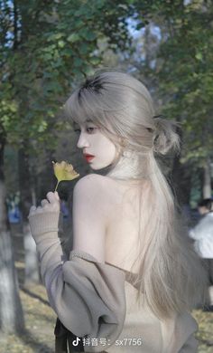 a woman with long white hair holding a flower