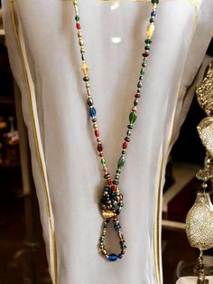 This vintage long multi-colored glass bead necklace is a beautiful and versatile accessory that will add a vibrant touch to any outfit. The necklace features an array of hand-strung glass beads in various shapes and sizes, each boasting rich, dynamic hues. From deep reds and blues to soft pastels and shimmering metallics, the colors in this necklace create a harmonious and eye-catching blend. The necklace's length allows it to be worn in multiple ways--draped in a single long strand for a dramatic effect, doubled up for a layered look, or even knotted for a more playful style. Each bead is unique, reflecting the artisanal craftsmanship that makes this piece truly one-of-a-kind. Multicolor Spiritual Long Necklace As A Gift, Spiritual Multicolor Long Necklace As Gift, Elegant Multicolor Long Necklace For Party, Handmade Multicolor Long Necklace For Party, Multicolor Long Necklace With Colorful Beads For Party, Elegant Multicolor Long Necklace With Faceted Beads, Festive Multicolor Long Beaded Necklace, Multicolor Czech Glass Beaded Necklace For Parties, Multicolor Round Beads Necklace For Party