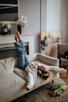 a woman laying on top of a couch in a living room