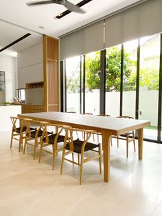 a dining room table and chairs in front of large windows