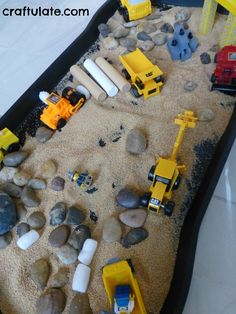 a sand tray filled with construction vehicles and rocks