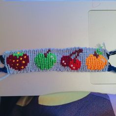 the beaded bracelet has fruit and vegetables on it