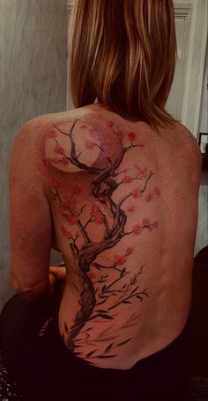 a woman with a tree tattoo on her back