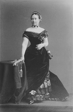 an old black and white photo of a woman in a dress