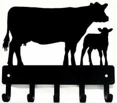 a cow and calf standing on top of a metal shelf next to each other in silhouette