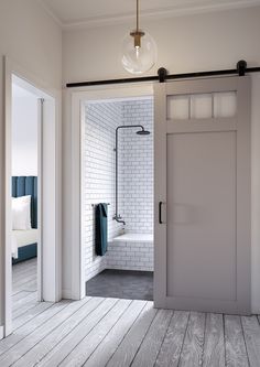 an open door leading to a bathroom with white brick walls and wood flooring in the background