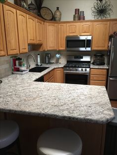 a kitchen with granite counter tops and stainless steel appliances