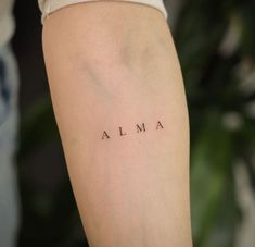 a woman's arm with the word alma written on it in cursive font