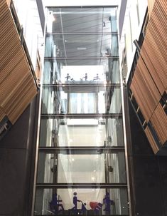 the inside of a glass and metal building with people on bikes in front of it