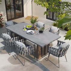 an outdoor dining table with chairs around it