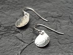 These super sweet drop earrings feature a 1/2 inch (12mm) domed and hammered sterling silver teardrop dropped from a sterling silver shepherd hook secured with a soft clear rubber backing- Perfect for everyday wear! If this is a gift? All my pieces come ready for gift-giving- Your piece will come in a gift box. I am happy to include a personalized note- Just write a brief (1-2 sentence) message in 'notes to seller' upon checkout and I will handwrite it on a little note card. A note about what to expect with shipping: It takes 5-7 business days after payment for your unique piece to be made & brought to a local courier, after which you will receive a shipping confirmation email with tracking information. Once shipped, it takes: TO CANADA: 3 business days to arrive if you are in Western Cana Dangly Earring, Shepherds Hook, Jewelry Minimalist, Jewellery Inspiration, Hammered Sterling Silver, Dangly Earrings, Blue Jewelry, Note Card, Super Sweet