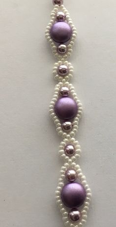 a white and purple beaded bracelet with pearls