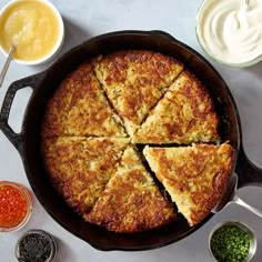 a pan filled with food next to sauces and condiments