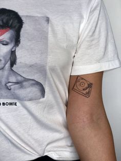 a man with a record player tattoo on his left arm