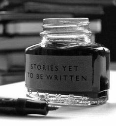 a bottle of ink sitting on top of a table next to a pile of books