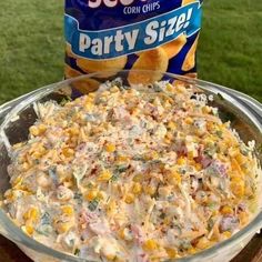 a bowl of party size corn salad next to a bag of chips