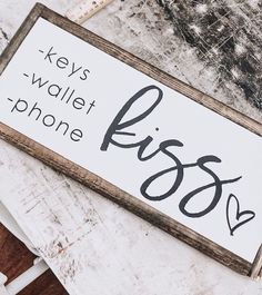 a wooden sign that says keys wallet phone boss on the side of a white table