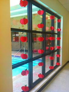 an apple themed window with apples cut out on the glass and hanging from it's sides