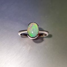 Coober Pedy solid crystal opal, half bezel set in a sterling silver ring. Opal  Weight: 1.1ct Size: 9x7mm Ring size AUS: O1/2 US: 7 3/4 Band diameter: 17.8mm Band width: 1.6-2.4mm tapered Materials: Solid opal, sterling silver Total weight: 2.3gm Oval Solitaire Opal Ring In Sterling Silver, Formal Oval Solitaire Opal Ring, Sterling Silver Oval Cabochon Opal Ring, Classic Opal Oval Cabochon Ring For Promise, Classic Opal Oval Cabochon Promise Ring, Classic Oval Cabochon Opal Promise Ring, Formal Oval Opal Ring In Sterling Silver, Oval Cabochon Opal Ring In White Gold, Oval Cabochon White Gold Opal Ring