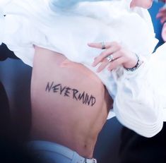 a woman with a tattoo on her stomach that says never mind in cursive writing