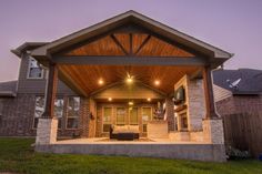 an outdoor covered patio with lights on the ceiling and seating area in the back yard