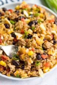 southwest turkey and rice skillet in a white bowl with a spoon on the side