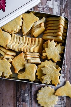 a tin filled with cut up cookies on top of a wooden table