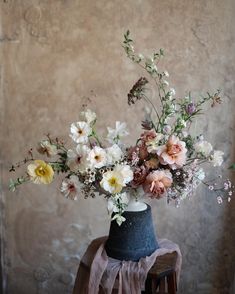 a vase filled with lots of flowers on top of a table