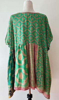 Artisan Kantha Bae Quilt Mini Dress. Dress falls just above the knee. With a high low hem, the dress is perfect for all ages. Soft, and Very Chic. An absolute favorite in daytime dresses. Why do we love it? Our best selling dress has been the midi version. Now... the shorter mini has been created. Now a best seller, surpassing the midi. This dress is a perfect example of maximizing the use of mixed prints to achieve a sophisticated fashion statement.The style is fresh, mixed prints engineered cr Green Bohemian Knee-length Midi Dress, Bohemian Green Knee-length Midi Dress, Green Patchwork Dress For Vacation, Bohemian Tunic With Asymmetrical Hem For Spring, Green Patchwork Dresses For Vacation, Spring Bohemian Tunic With Asymmetrical Hem, Flowy Patchwork Short Sleeve Dress, Bohemian High-low Hem Flowy Dress, Bohemian Flowy Dress With High-low Hem