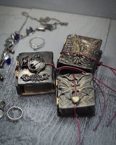 jewelry is laid out on the floor next to an open book and ring holder,