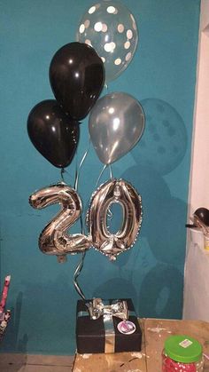 a table with balloons and presents on it in front of a wall that says 2013