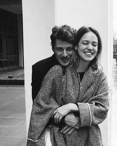 a man and woman hugging each other on the street