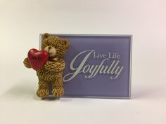 a teddy bear holding a red heart with the words live life joyfully written on it