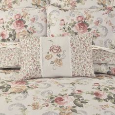 a bed with floral comforter and pillows on top of it, in front of a white background