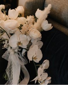 a bouquet of white flowers sitting on top of a couch