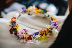 a close up of a flowered headband on a white cloth with people in the background