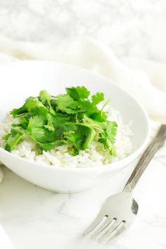 a white bowl filled with rice and cilantro