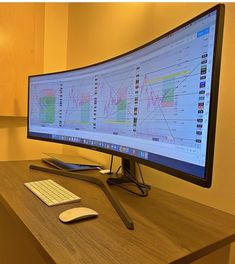 a computer monitor sitting on top of a wooden desk next to a keyboard and mouse