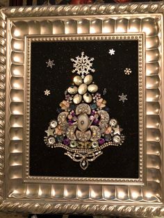 a christmas tree made out of buttons in a silver frame